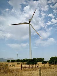 Windmill on field against sky