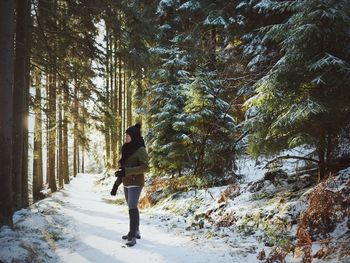 Woman in snow covered forest