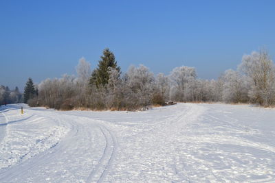 Snow covered landscape against clear sky