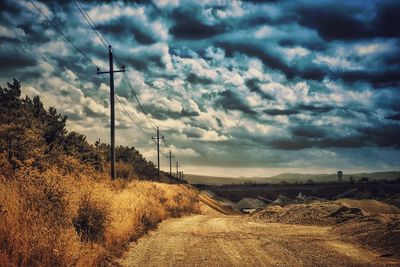 Road by field against sky