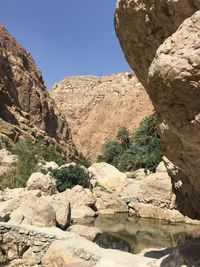 Rock formations by mountains against sky