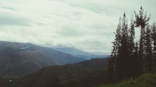 Scenic view of mountains against cloudy sky