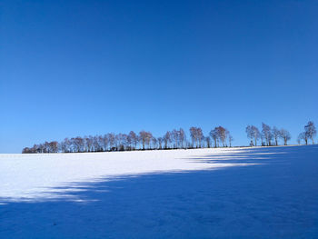 Scenic view of frozen landscape against clear blue sky