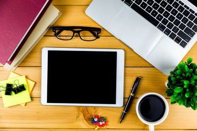 Coffee cup and laptop on table