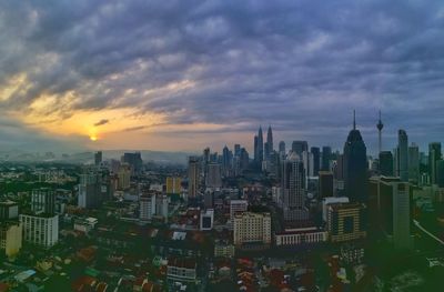 Aerial view of cityscape against cloudy sky