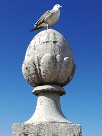 Low angle view of statue against clear blue sky