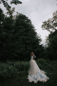 Bride standing by plants