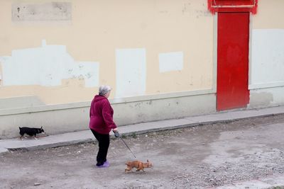 Woman with dog against building in city