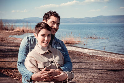Beautiful couple sitting on the shore of lake bracciano in italy.