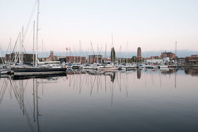 Sailboats moored in harbor