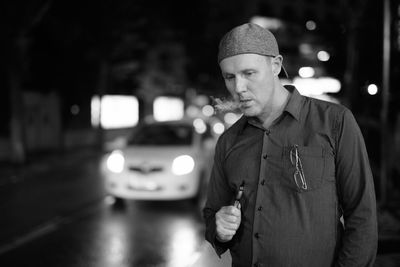 Man looking at illuminated camera at night