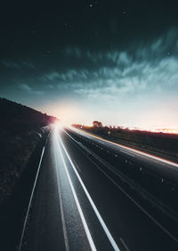 Railroad tracks against sky at night