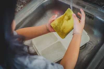 Close-up of woman cleaning plate at home