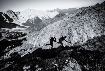 People on mountain against sky
