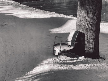 Shadow of a chair on snow by the lake