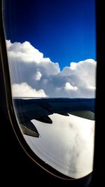 Scenic view of cloudy sky seen through airplane window