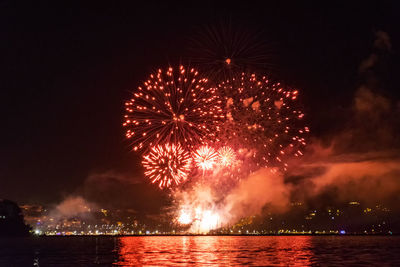 Firework display over river at night