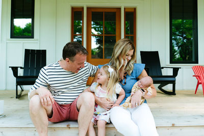 Straight on portrait of a family laughing and smiling at each other