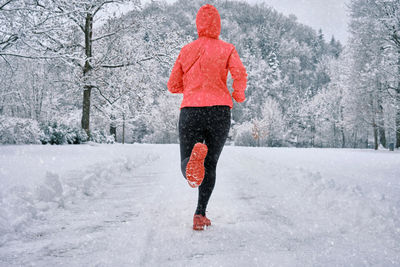 Running woman, girl runner on snow in park winter day. run, sport concept, leisure and freedom.