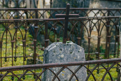 Close-up of metal gate against fence