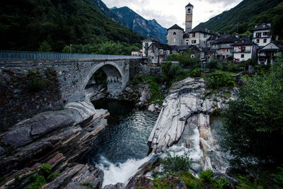 Arch bridge over river against buildings