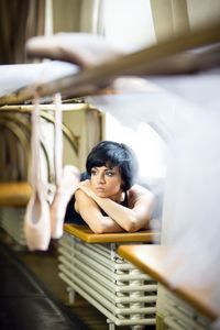 Portrait of young woman sitting on railing