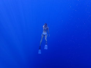 Rear view of young woman swimming in sea