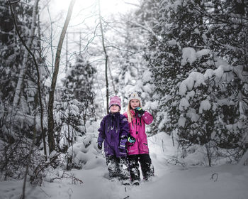 Full length of a girl in snow covered forest