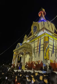 Low angle view of illuminated carousel against clear sky at night