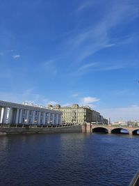 Arch bridge over river against blue sky