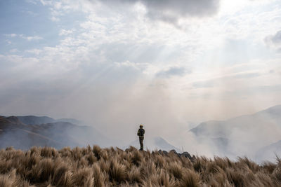 Man standing on field against sky