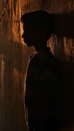 Close-up portrait of silhouette man standing against wall