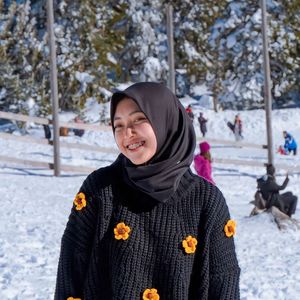 Portrait of woman standing on snow covered field