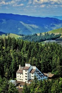 Houses by trees and mountains against sky