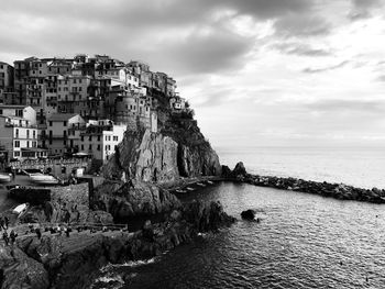 Scenic view of sea by buildings against sky