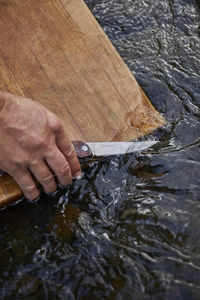 Washing knife and cutting board in fresh stream water