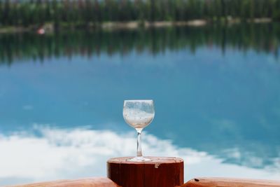 Close-up of drink on table against lake