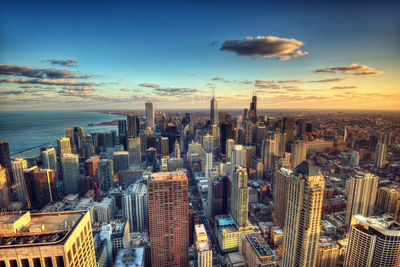 Aerial view of modern buildings against sky during sunset