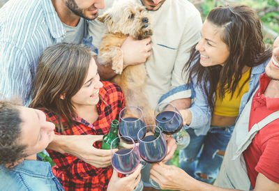 High angle view of happy friends toasting wineglasses during social gathering