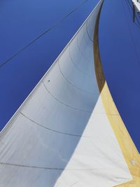 Low angle view of sailboat against clear blue sky