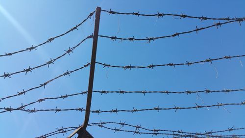 Low angle view of barbed wire against sky