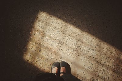 Low section of person standing on tiled floor