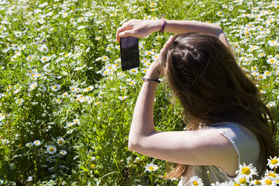 Women with dress take photo in field of daisy flowers, travel theme