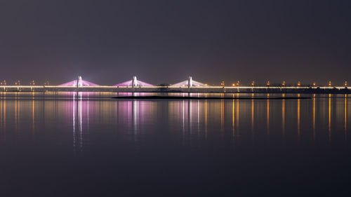 View of bridge over river at night