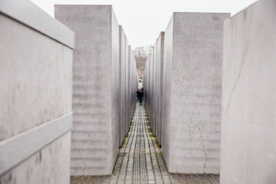 Rear view of man walking on wall of building