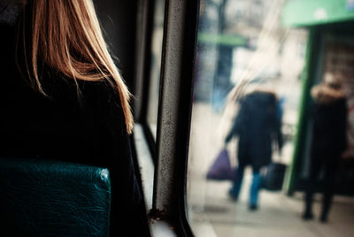 Rear view of woman sitting in bus