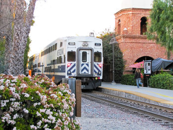 Train by railroad tracks against sky