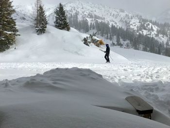 Man skiing on snowcapped mountains during winter
