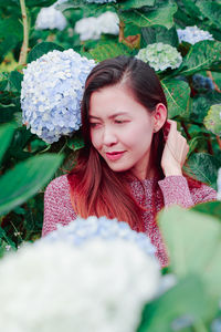 Mid adult woman by flowering plants in park