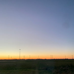 Scenic view of field against clear sky during sunset